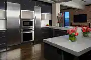 Modern L-Shaped Kitchen Design With Seamless High Gloss Finish And Elegant Herringbone Backsplash