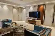 Luxurious Living Room with Elegant Blue Velvet Seating and Modern TV Setup