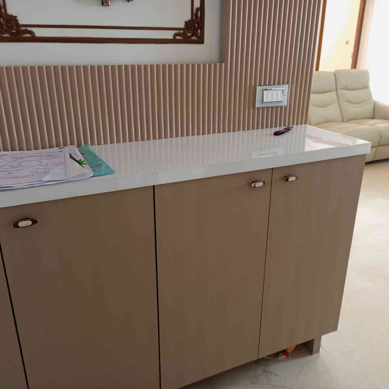 Modern Console With Glossy White Countertop And Textured Beige Cabinets