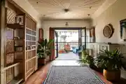 Beautifully Styled Bohemian-Inspired Hallway Leading Sunlit Balcony
